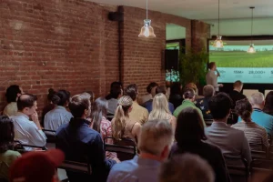 Presentation setup at LOFT39 showing a rental projector screen and theater seating in an industrial chic loft.