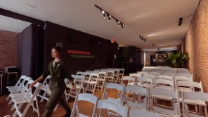 Theater-style seating setup using white garden chairs in a modern NYC loft space for a corporate presentation.