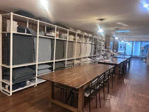 Neatly organized retail display of luxury linens and towels on white shelving in a Midtown Manhattan showroom.