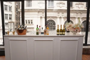 The LOFT39 bar station prepared with premium glassware and a window view of Midtown.