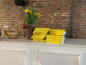 Minimalist display of "After the Idea" books stacked for a corporate book launch and networking event.