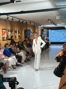 Fashion model posing in a white couture power suit on a runway at an immersive brand activation.