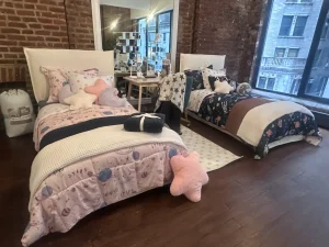 Large warehouse gallery floor with exposed brick and hardwood floors set up for a retail product showcase.