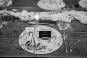 Close-up of a premium place setting at LOFT39 including marble-patterned plates and wine glassware for an executive dinner.