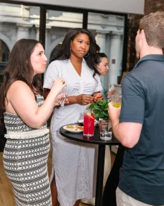 Curated table settings and floral arrangements for a professional business dinner in a chic loft.