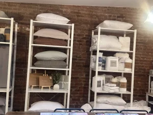 Bright, sunlit showroom area featuring twin bed setups and floor-to-ceiling windows for a product preview.
