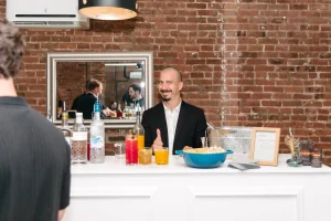 Business professionals engaging in conversation at a corporate happy hour in a sun-drenched Manhattan loft.