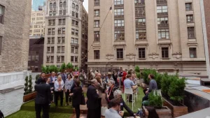 A cocktail reception on the LOFT39 rooftop terrace with guests networking against the backdrop of Midtown Manhattan architecture.