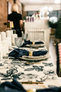 A romantic nighttime wedding ceremony setup on a rooftop with white chairs and candlelit aisle markers.
