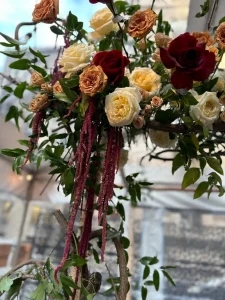 Perspective shot of a long wedding table set for dinner with blue napkins and designer floral linens.