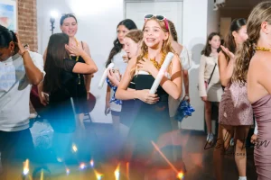 Professional event MC hyping up a crowd of teens on the dance floor at a loft-style Mitzvah celebration in NYC.
