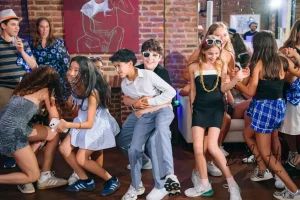 eenagers dancing to a live DJ under custom party lighting at a New York City Bat Mitzvah reception.