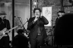 Timeless black and white photograph showcasing a unique live DJ and live musician mashup performance at a milestone birthday.