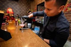 Stylishly dressed corporate guests socializing in formal holiday attire at an upscale Midtown venue.