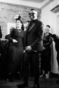 Elegant black and white close-up of sophisticated guests clinking champagne glasses during a milestone birthday toast.