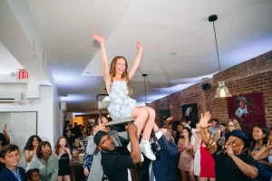 Modern, non-religious Bat Mitzvah decor setup featuring custom lighting and balloon arches in an industrial-chic NYC loft.